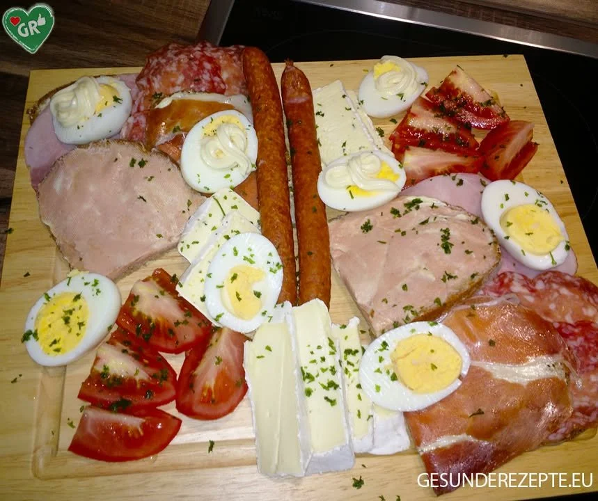 Bayerische Brotzeit mit Wurst, Käse und Brezeln auf einem Holzbrett
