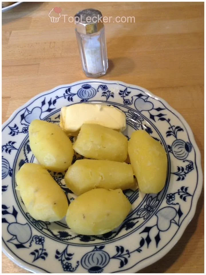 Leckere Erdapfel mit Butter auf einem Teller serviert