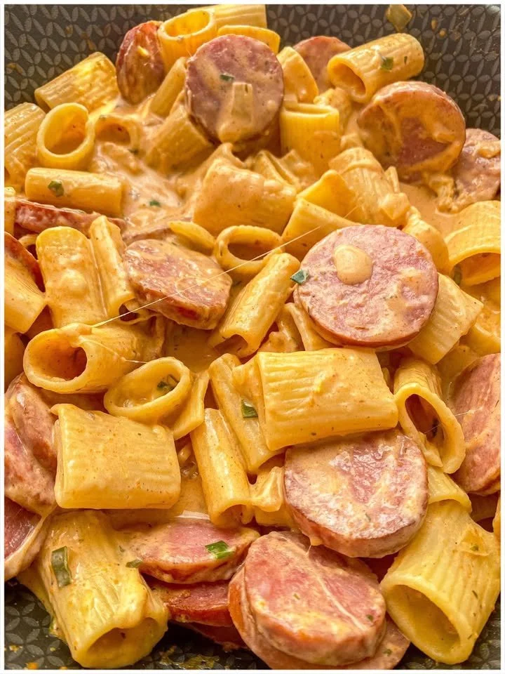 Pasta mit Wurst und Käsesauce auf einem Teller serviert