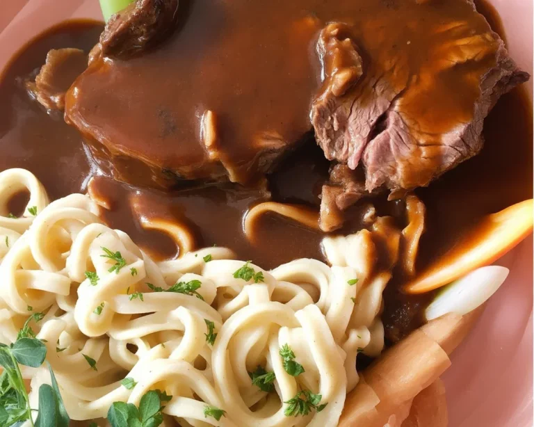 Traditioneller Sauerbraten serviert mit rotem Kohl und Spätzle.