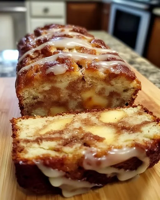 Saftiger Apfel-Zimt-Kuchen auf einem Teller mit Zimtstangen und Äpfeln