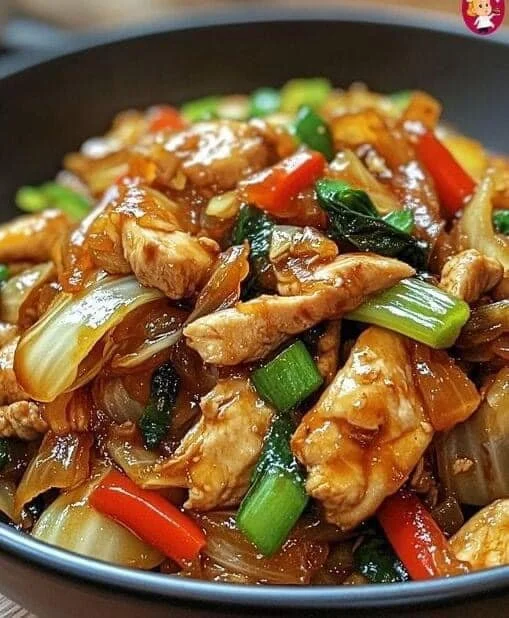 Chinesische Hahnchenpfanne mit Spitzkohl und Zwiebel auf einem Teller serviert
