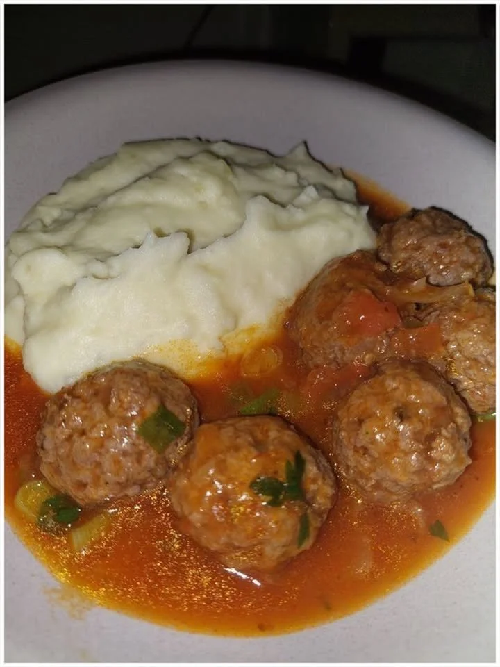 Fleischbällchen in Tomatensauce mit Kartoffelpüree auf einem Teller