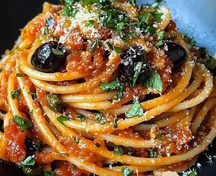 Puttanesca Pasta mit Sardellen auf einem Teller serviert