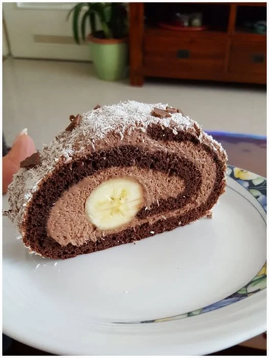 Schoko Banane Rolle mit Schokolade und Bananenfüllung auf einem weißen Teller