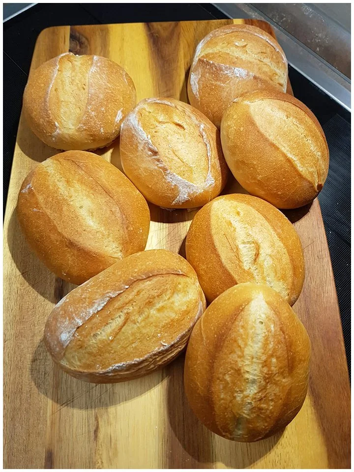 Frisch gebackene Sonntagsbrötchen auf einem Holzbrett