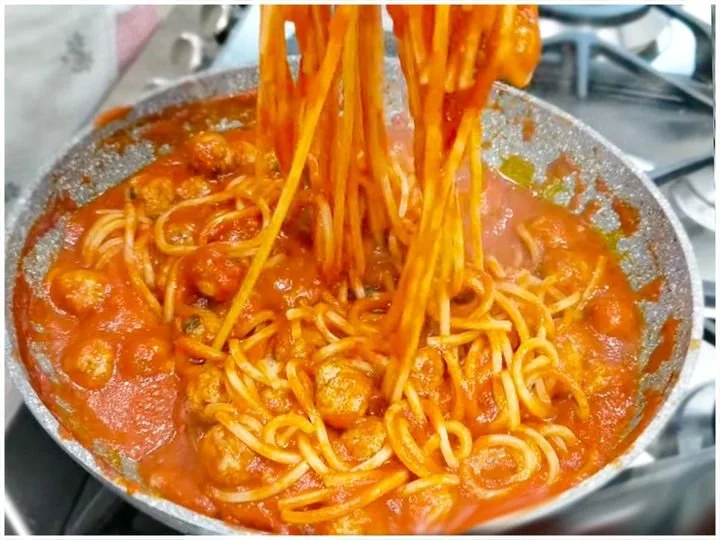 Leckere Spaghetti-Hackbällchen-Pfanne mit frischen Zutaten auf einem Teller