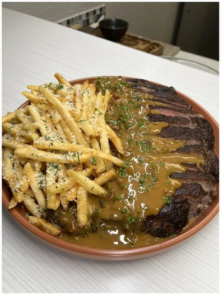 Steak mit Pfefferrahmsoße und Parmesan-Pommes auf einem Teller