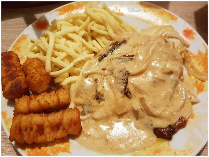 Zwiebel Sahne Hähnchen in cremiger Sauce auf einem Teller serviert