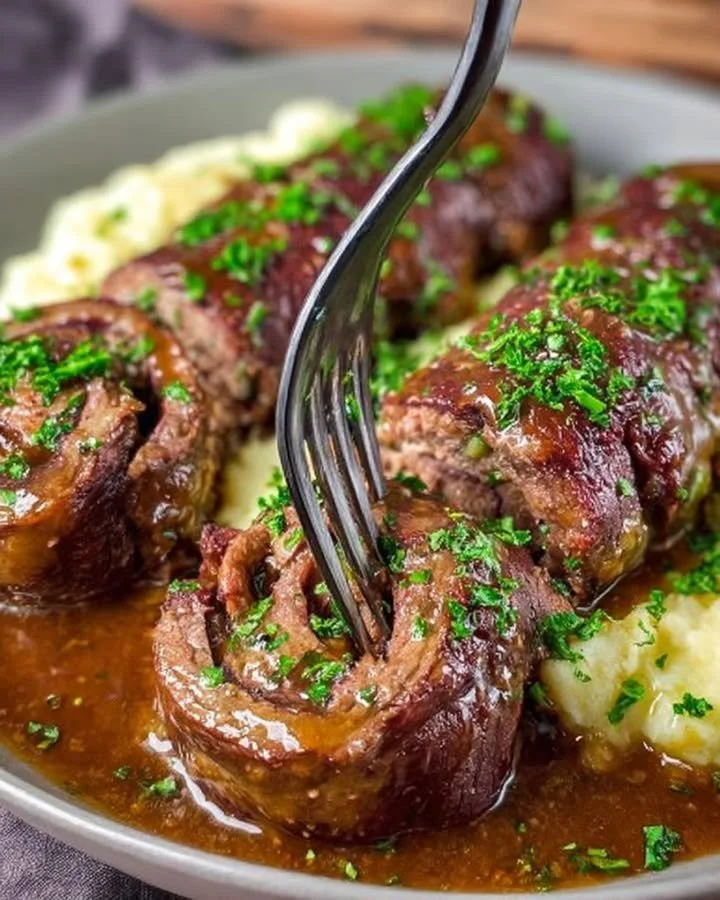 Leckere Rinderrouladen auf einem Teller, herzhaft gefüllt mit Gemüse und Speck