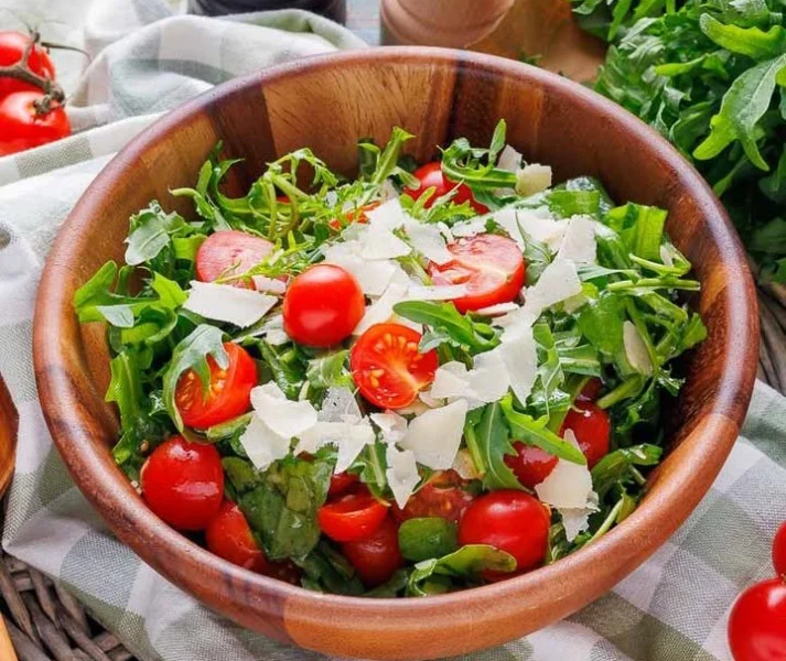Frischer Rucola-Salat mit saftigen Tomaten auf einem Teller