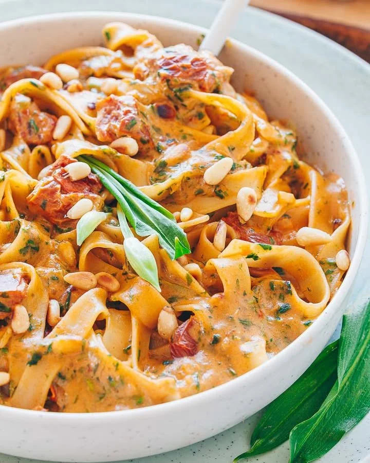 Bärlauch-Nudeln mit frischem Bärlauch auf einem Teller angerichtet