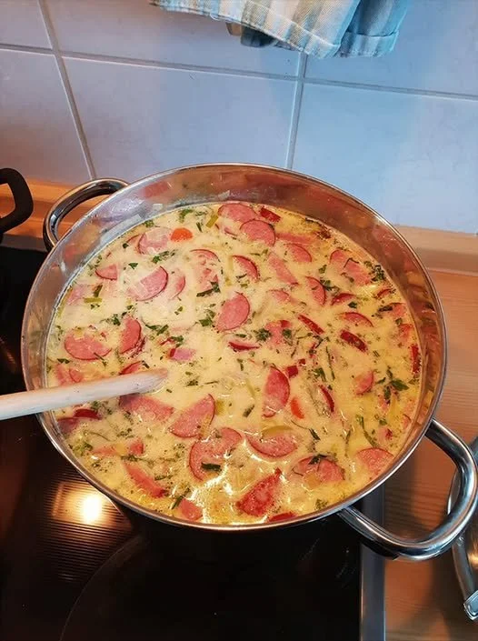 Cabanossi-Käse-Suppe in einer Schüssel, garniert mit frischen Kräutern