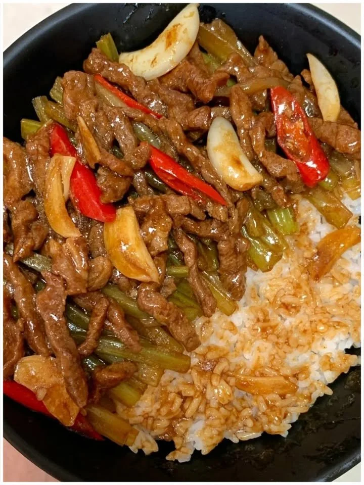 Chinesisches Rindfleisch mit Zwiebeln und Paprika auf einem Teller serviert.