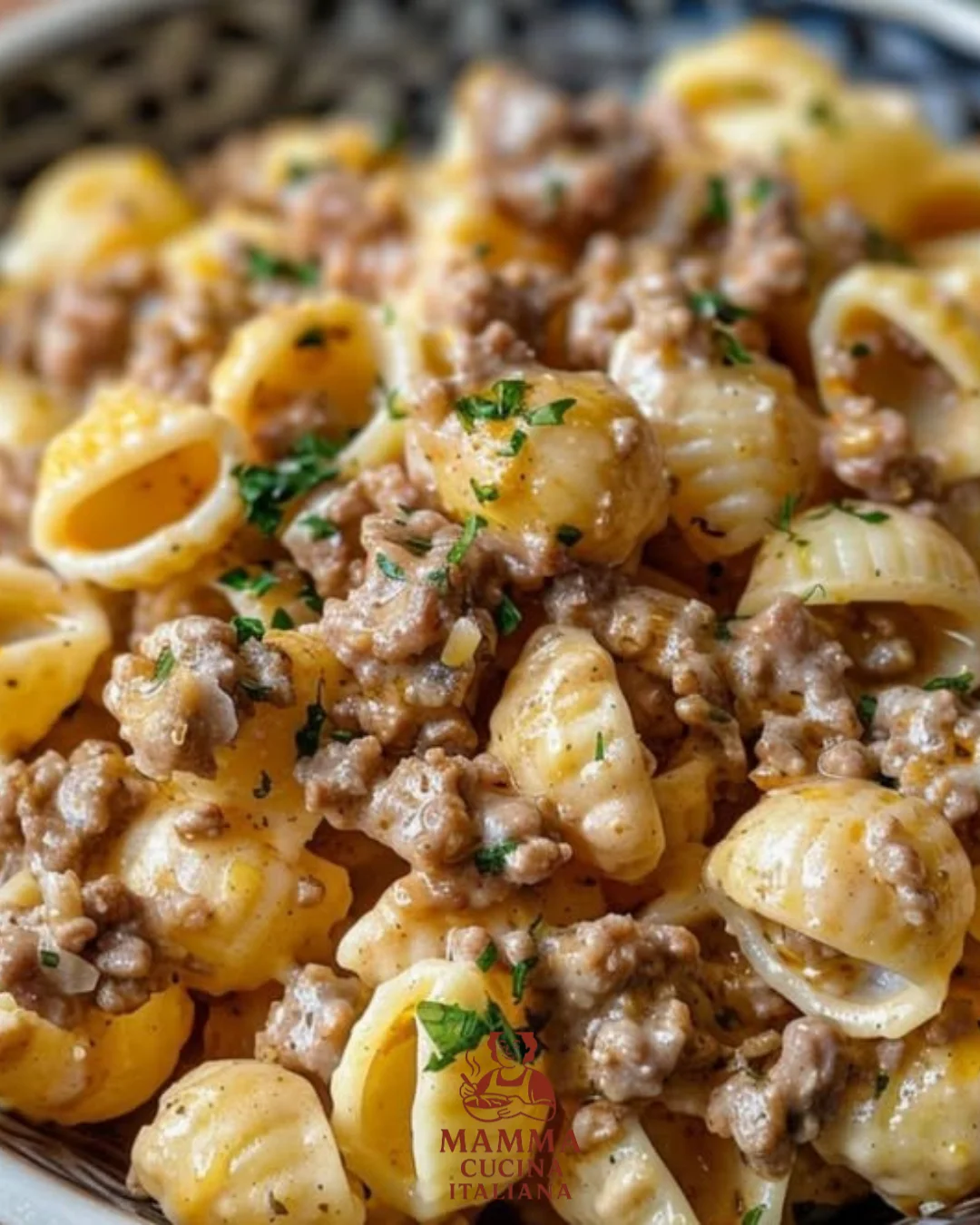 Cremiges Rinderhack mit Muschelnudeln auf einem Teller serviert.