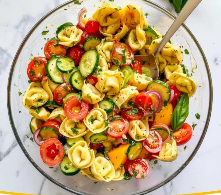 Frischer Tortellinisalat mit Gemüse und Dressing auf einem Teller