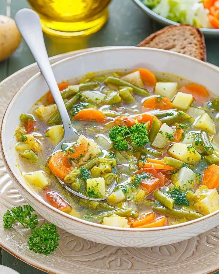 Gemüse-Eintopf mit Kartoffeln in einer bunten Schüssel serviert