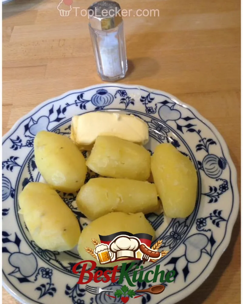 Ein leckerer Erdapfel mit Butter auf einem Teller serviert.