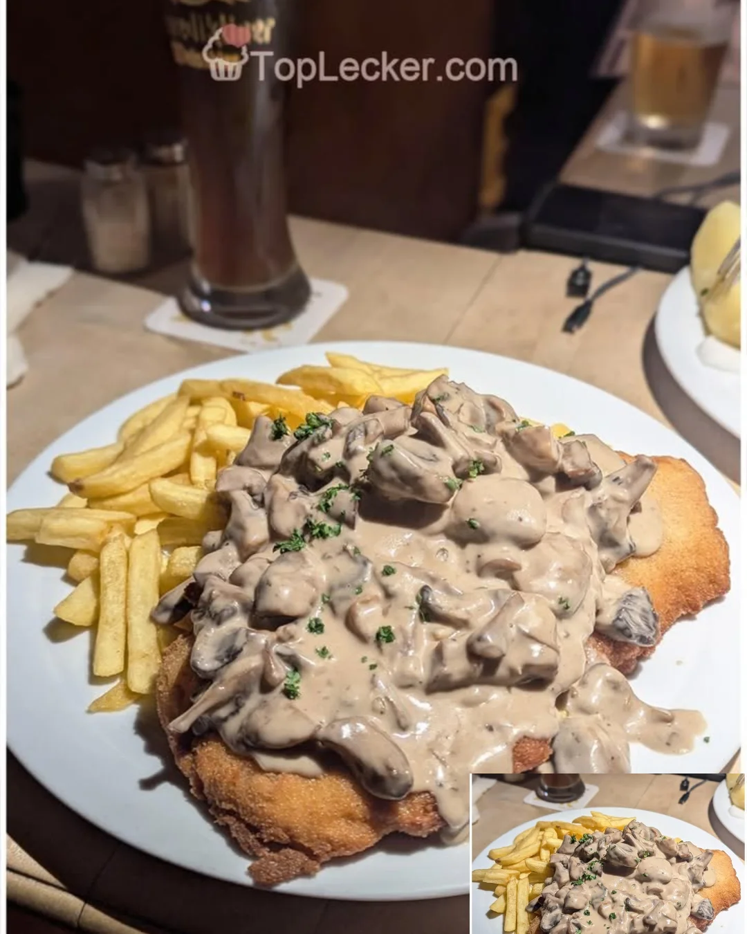 Schnitzel mit Pommes und selbstgemachter Champignonsauce auf einem Teller serviert
